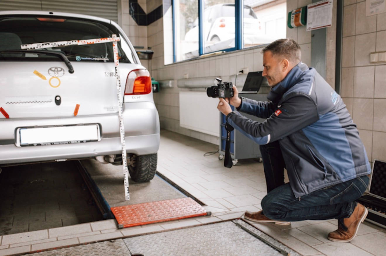 Jens Streubel fotografiert einen Heckschaden mit Maßstab
